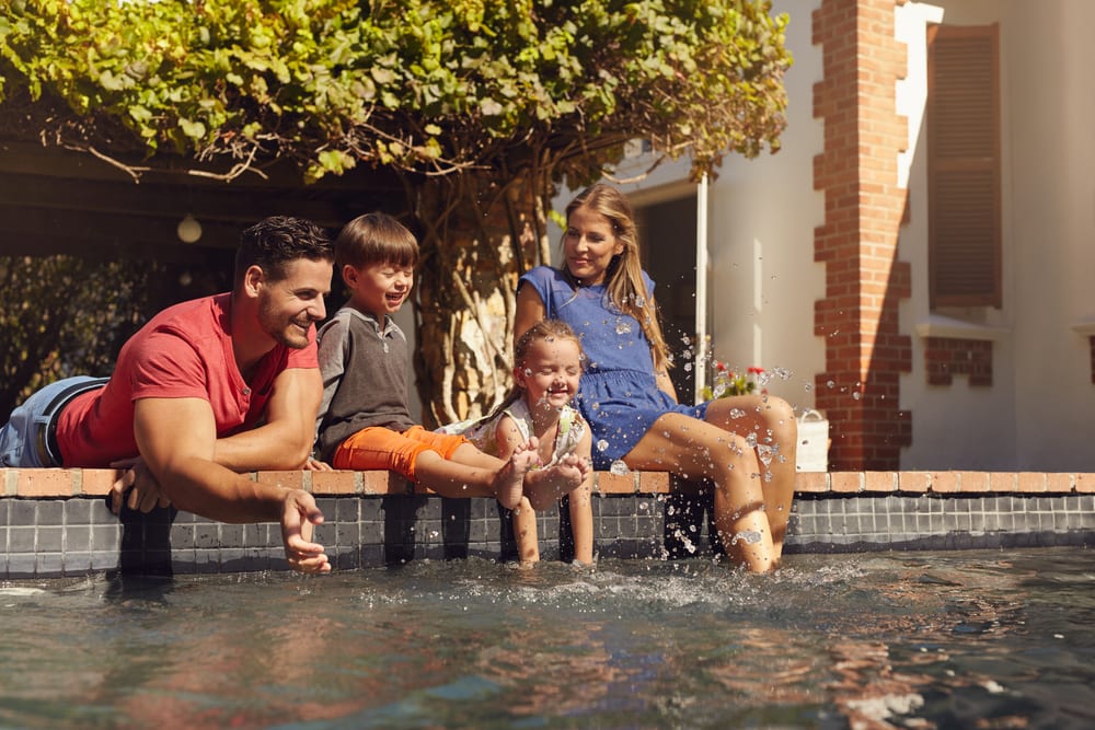 Family wading in their backyard pool