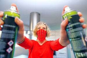 Young woman at home using air spray